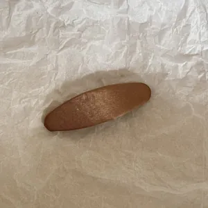 Vue macro détaillée montrant la texture d'une pince à cheveux en tissu marron