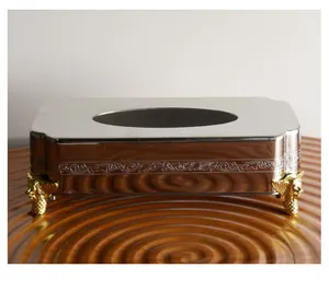 Detailopname van luxe roestvrijstalen tissuehouder met decoratieve gouden leeuwenpoten