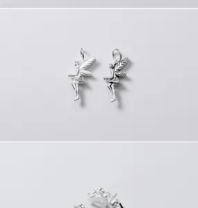 Detailed macro shot of vintage 925 sterling silver angel wing charms for DIY jewelry.