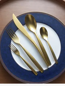 Detailed overhead view of a 5-piece gold stainless steel cutlery set on a blue plate
