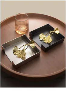 Modern stainless steel napkin holder with golden ginkgo leaf weight in silver and black