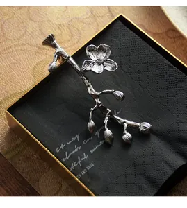 Detalle de un peso para servilletas de acero inoxidable con diseño floral de lujo