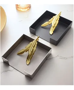 Detail view of a creative stainless steel napkin holder with golden feather weights.