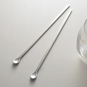 Deux cuillères à mélanger minimalistes en acier inoxydable mat à long manche pour café.