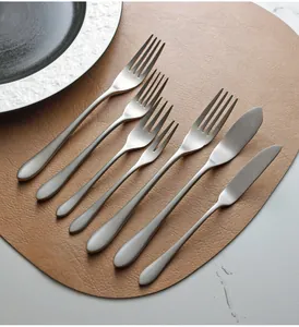 Close-up of retro silver stainless steel cutlery set on leather placemat