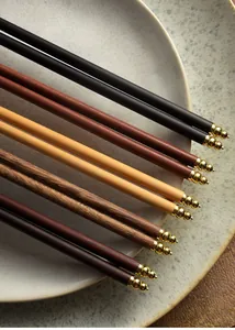 Macro view of assorted premium wooden chopsticks featuring elegant gold plated end caps.