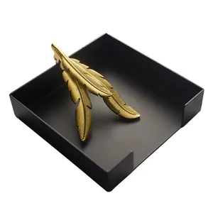 Modern golden feather napkin weight with black square tray for restaurant table decor