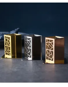 Three stainless steel toothpick holders in gold, silver, and rose gold with geometric cutouts.