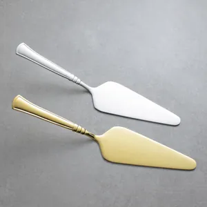 Premium stainless steel cake and pizza servers in gold and silver finishes on a grey stone background