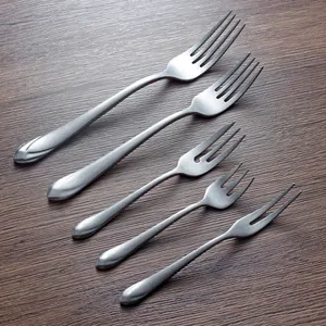 Set of 5 304 stainless steel forks with a distressed matte finish on wood background