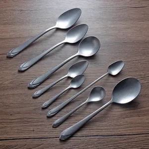 Set of 8 vintage 304 stainless steel spoons in various sizes on wood background