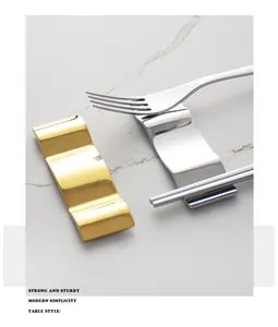 Detail of gold and silver 304 stainless steel wavy cutlery rests with fork