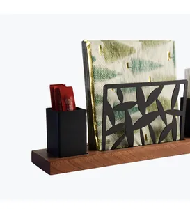 Close-up view of the black metal hollow napkin holder and wood base storage box.