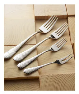 Detailed view of 304 stainless steel hammered forks set on a rustic wooden background
