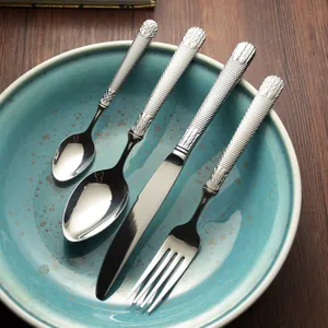 Elegant stainless steel cutlery set with embossed handles on a blue ceramic plate
