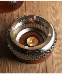 Detailed top view of stainless steel tea warmer with lit candle on wooden base