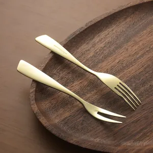 Elegant 304 gold stainless steel dessert and fruit fork set on a wooden plate.