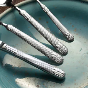 Luxury stainless steel cutlery set with elegant textured handles and wheat pattern.