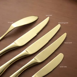 Elegant gold 304 stainless steel cutlery set with various knives on wooden surface