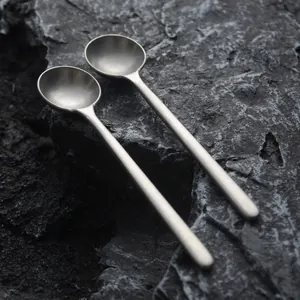 Pair of vintage Japanese style matte stainless steel coffee stirring spoons on rock