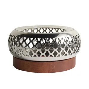 Elegant retro stainless steel tea warmer with hollow lattice design and circular wooden base