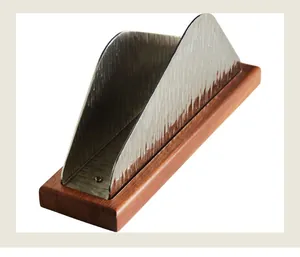 Close-up detail of a hammered stainless steel napkin holder with a solid wooden base