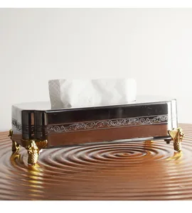 Elegant detail van een roestvrijstalen tissuedoos met gouden decoratieve poten