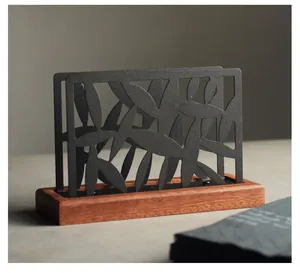 Modern black metal leaf design napkin holder with wooden base for tabletop storage
