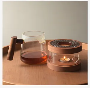 Detailed macro view of walnut wood candle tea warmer and teapot on a rustic wooden tray