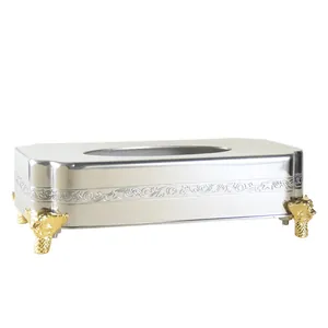 Luxe roestvrijstalen tissuebox met gouden pootjes en bloemengravures voor chique decoratie.