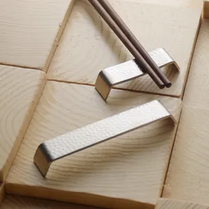 Poggia bacchette minimalista in acciaio inox 304 martellato su sfondo in legno naturale