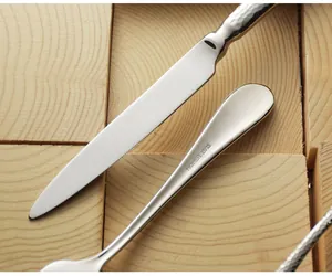 Detailed macro view of HOHEA hammered 18/10 stainless steel steak knife and polished cutlery.