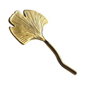 Elegant golden ginkgo leaf stainless steel chopstick rest holder for luxury dining.