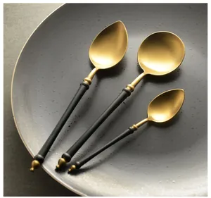 Detail view of 304 stainless steel spoons with elegant gold finish and black handles