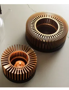 Detailed macro view of two golden tea warmers with a lit candle on a marble surface.