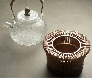 Detailed view of hammered glass teapot set with unique hollow metal tea warmer
