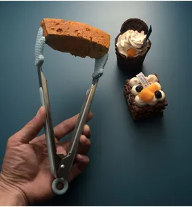 Close-up view of stainless steel tongs with silicone tips clamping a piece of bread