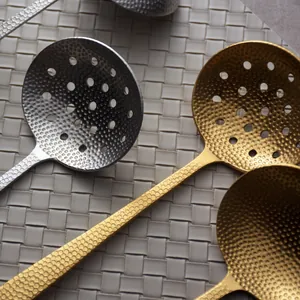 Elegant hammered stainless steel slotted spoon with long handle in gold and silver finish.