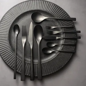 Elegant matte black stainless steel cutlery set for steak and dessert on a plate