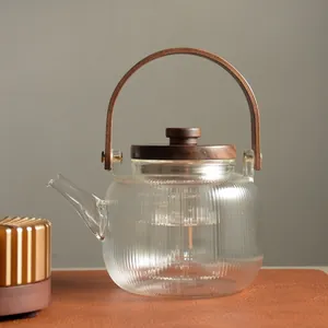 Elegant minimalist ribbed glass teapot with wooden handle and matching candle warmer base