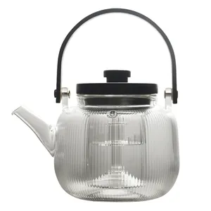Elegant ribbed glass teapot featuring a minimalist matte black handle and lid on white background