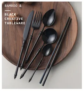Black 304 stainless steel cutlery set with bamboo-inspired handle design on a wooden tray