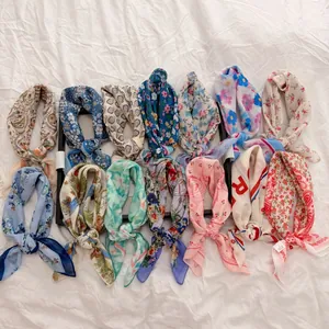Variety of floral pastoral style cotton linen square scarves arranged on white fabric
