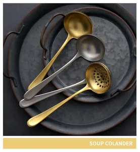 Macro view of vintage gold and silver 304 stainless steel soup spoons and colander.