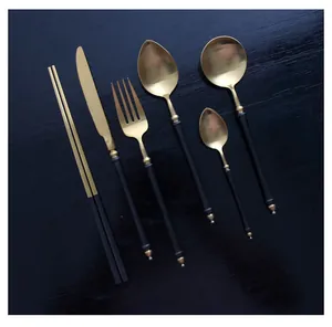 Detailed view of matte black and gold stainless steel cutlery set with bamboo design