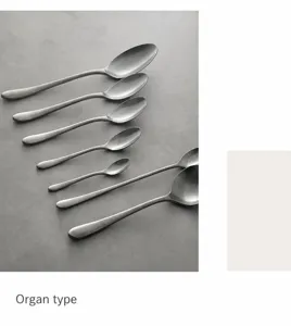Détail macro de différentes tailles de cuillères en acier inoxydable vieilli sur pierre