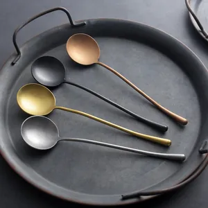 Set of four long-handled metallic spoons in copper, gold, black, and silver finishes