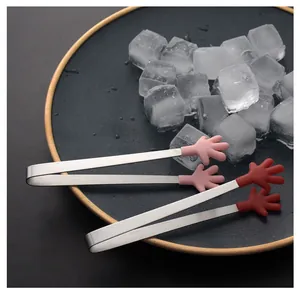 Close-up of cute mini silicone hand-shaped tongs for ice cubes and snacks on a plate