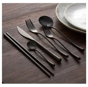 Detailed display of a 6-piece matte black stainless steel cutlery set on rustic wood
