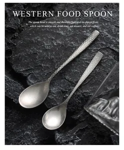 Close-up of vintage hammered 304 stainless steel coffee spoons with matte finish on rock.